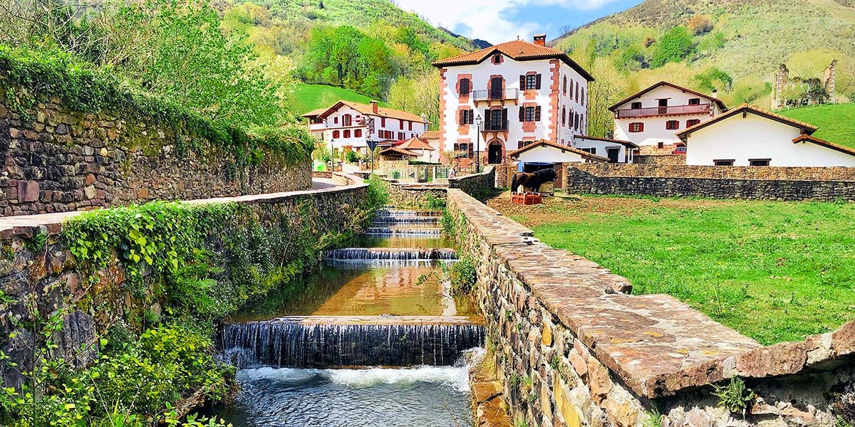 Un canal y, al fondo, el pueblo de Urdax y las montañas. Foto: Iker Beroiz